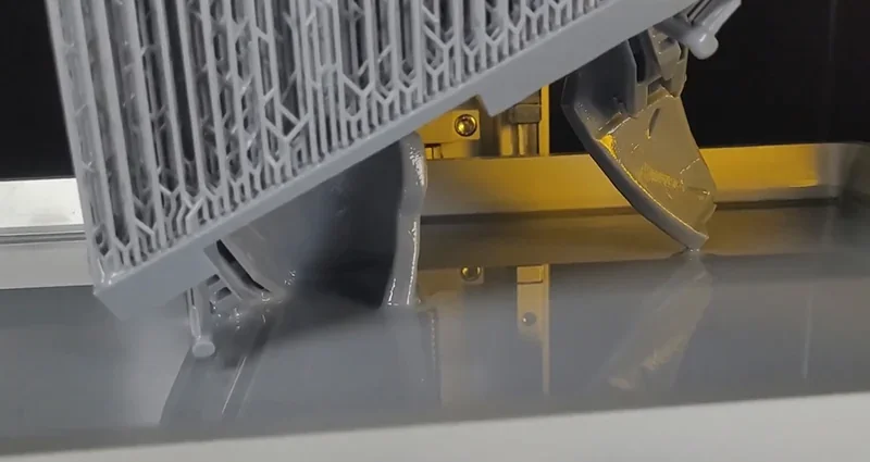 Phrozen Sonic Mega 8K v2 printing detailed gray resin parts in progress, showcasing intricate support structures and reflective surface.