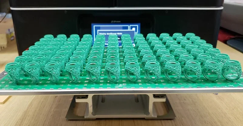 Phrozen Sonic Mega 8K V2 3D printer with intricate green resin rings on the build plate, showcasing high-detail printing capability.