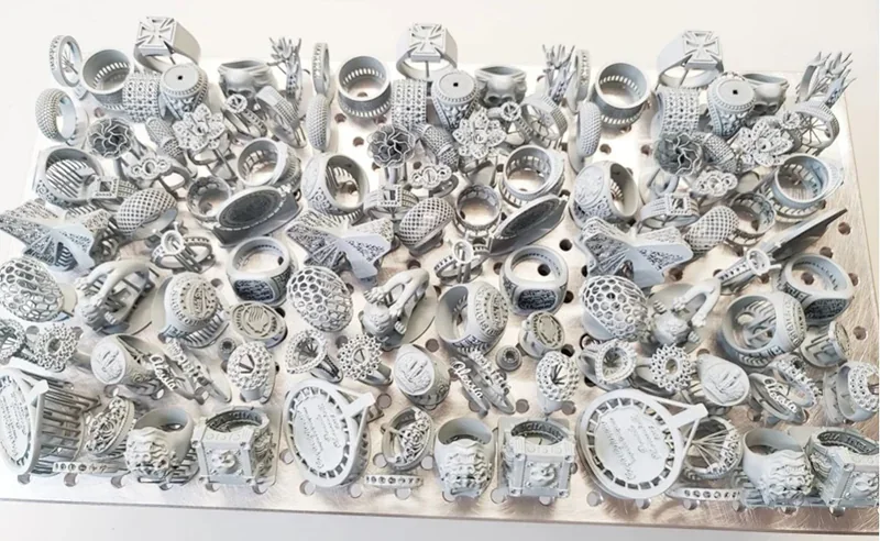 Phrozen Sonic Mega 8K V2 print bed filled with detailed gray 3D-printed jewelry-like samples, showcasing intricate designs and precision.