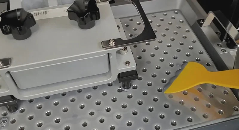 Phrozen Sonic Mega 8K V2 printer setup with perforated build plate and yellow scraper tool.