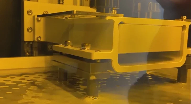 Phrozen Sonic Mega 8K V2 in action, with a close-up of the build plate submerged in resin, demonstrating precision 3D printing technology.