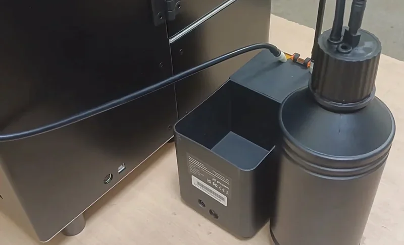 Phrozen Sonic Mega 8K V2 3D printer with connected external tank on a wooden surface.