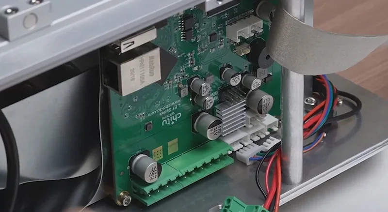 Phrozen Sonic Mega 8K V2 circuit board close-up, showcasing components, wiring, and connectors on a metal chassis, demonstrating advanced internal design.