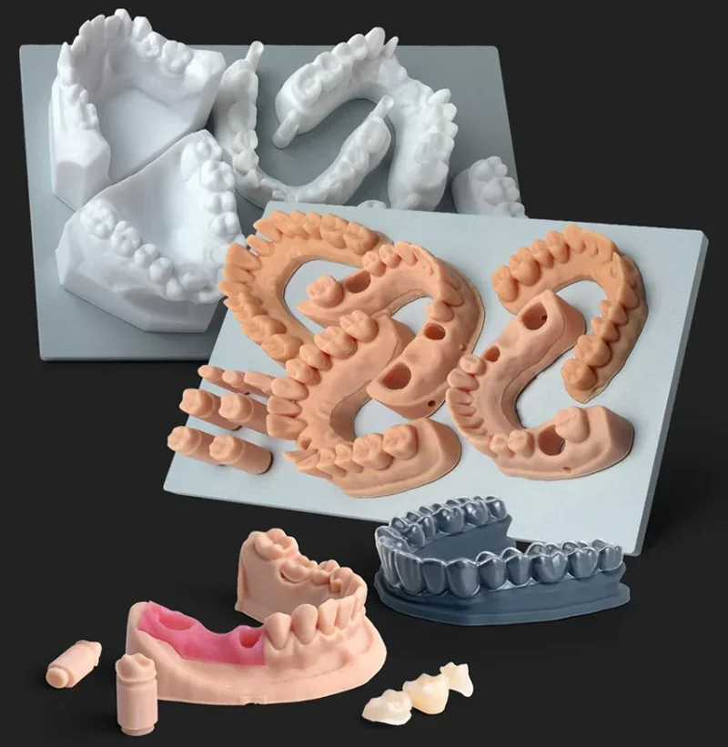 Dental models and parts created by Phrozen Sonic XL 4K Plus, showing precision and detail in various colors and shapes on a dark background.