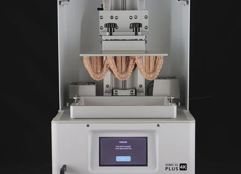 Phrozen Sonic XL 4K Plus 3D printer showcasing printed dental model with screen display, highlighting precision and advanced printing technology.