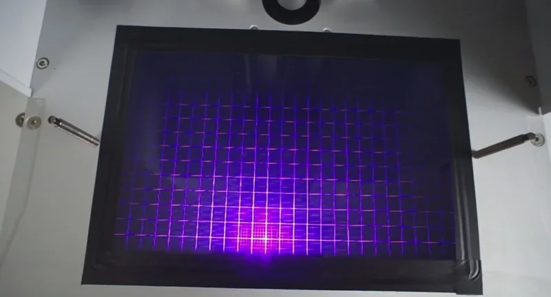 Phrozen Sonic XL 4K Plus printer displaying a lit grid pattern under UV light, showcasing its precision and build area for creating 3D printed parts.