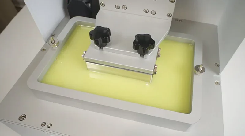 Phrozen Sonic XL 4K Plus in action, showing resin vat with build platform submerged in yellow resin, showcasing precise 3D printing technology.