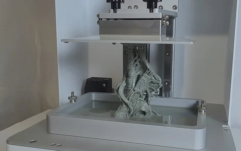 Phrozen Sonic XL 4K Plus 3D printer with partially printed detailed model emerging from resin vat in a minimalistic setting.