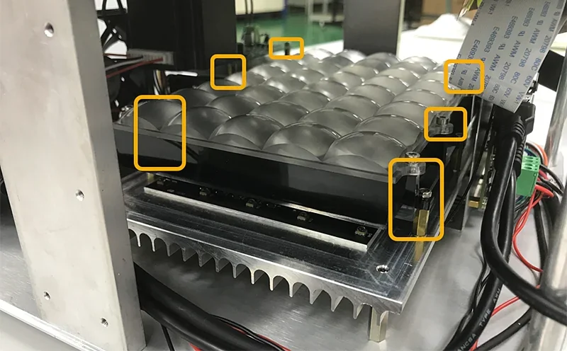 Phrozen Sonic XL 4K Plus uncovered print area with mechanical components visible, showcasing part samples and wiring in a technical setting.