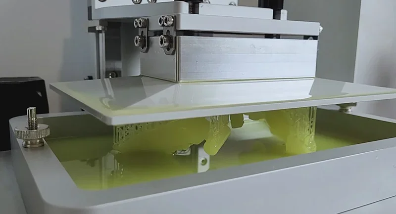 Phrozen Sonic XL 4K Plus 3D printer with resin vat, creating detailed parts in a clean, precise setup.