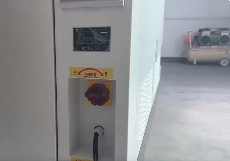 Piocreat G12 3D printer's emergency stop button and power cable with visible branding in an industrial setting.