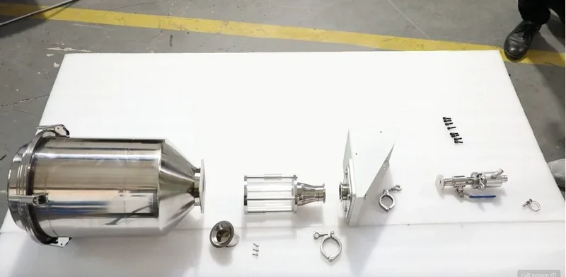 Piocreat G12 components arranged on a white surface, showing a series of metal parts and fixtures, likely 3D printed, in a workshop setting.