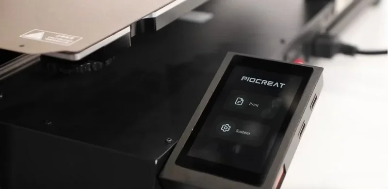 Piocreat G5 3D printer control screen interface, showing options for Print and System. The device features a sleek black design with a touch display.