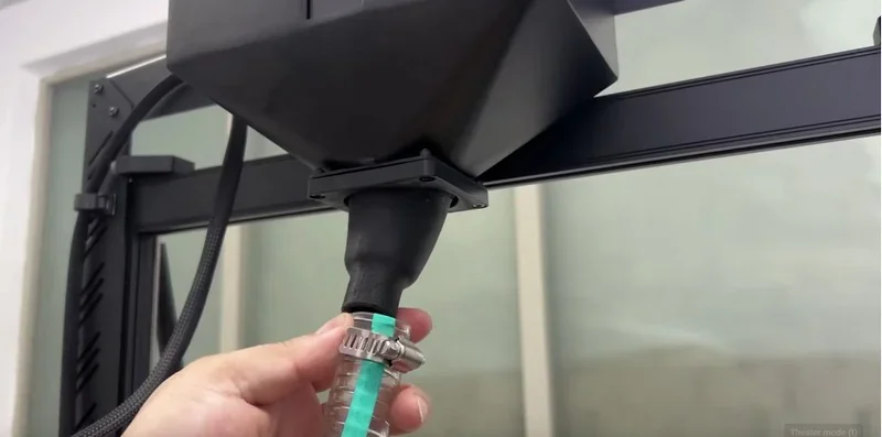 Piocreat G5 3D printer setup close-up, showing a hand connecting a tube to a funnel-like component on the printer frame.