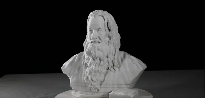 Bust of a bearded man 3D printed by Piocreat G5, showcasing detailed texture and precision, set on a dark backdrop.