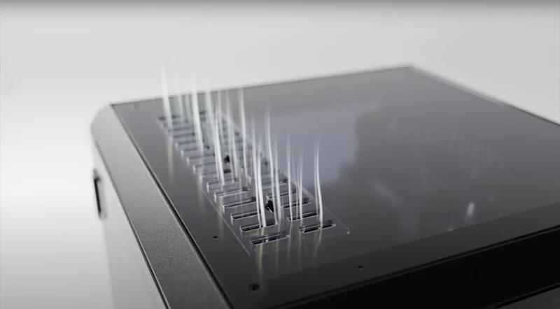 Prusa Core One's sleek 3D printer with multiple fine filament threads rising from the top, showcasing precision and innovative design.