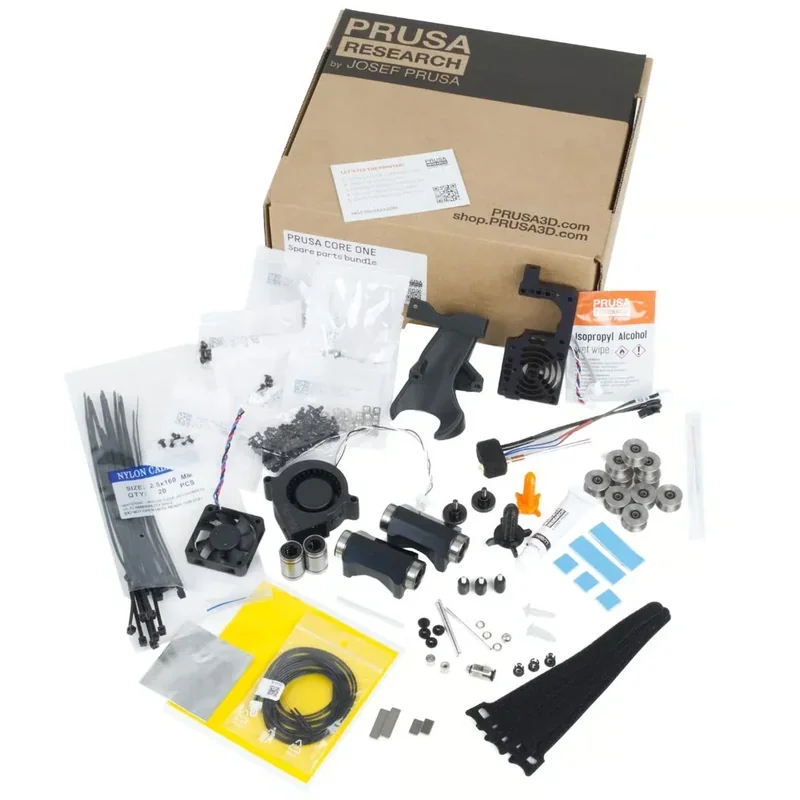 Prusa Core One spare parts bundle with components laid out, including wires, fan, motor parts, gear wheels, and branded packaging in a Prusa Research box.