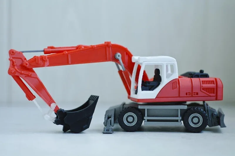 Red and white toy excavator with detailed features, created using a Prusa Mini 3D printer, displayed on a light surface.