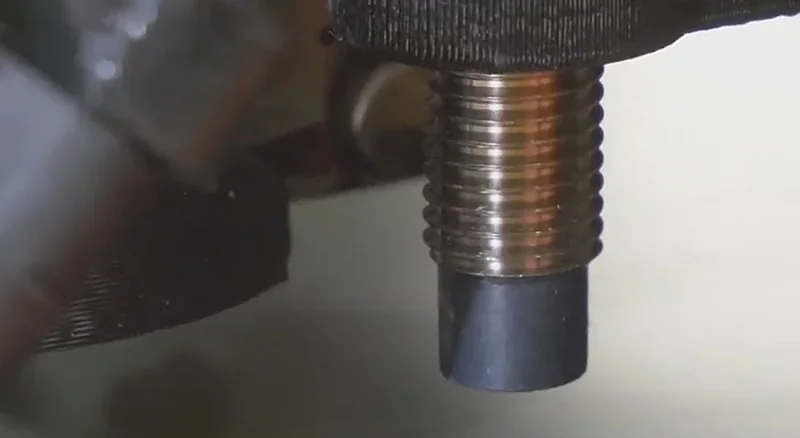 Close-up of Prusa Mini 3D printer nozzle, showing detailed filament extrusion, highlighting precision mechanics and capability for creating parts.