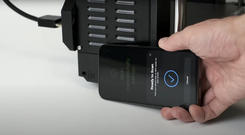 Prusa MK4 3D printer setup with a hand holding a smartphone, showing WiFi configuration status.