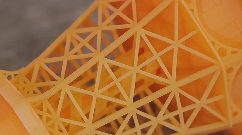 Detailed lattice structure 3D printed by Prusa SL1S in orange resin, highlighting intricate geometric design.