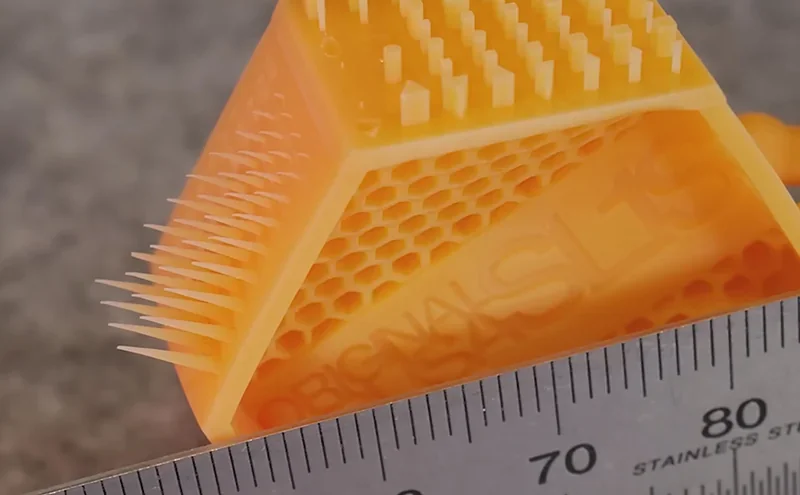 3D-printed hexagonal structure with spikes beside a ruler, created by Prusa SL1S, showcasing precision and detail.