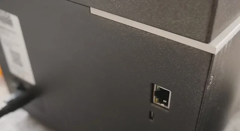 Close-up of the Prusa SL1S 3D printer's rear panel, featuring a network port and part of the textured black casing.