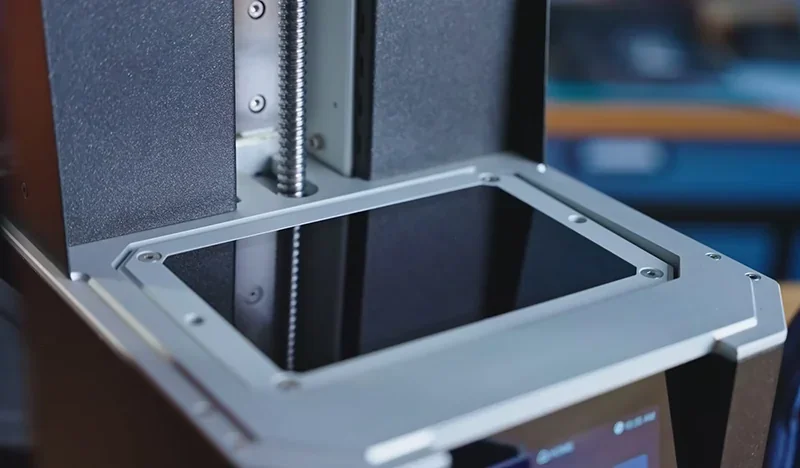 Prusa SL1S 3D printer close-up showing the resin vat and build plate area, highlighting professional design and robust construction.