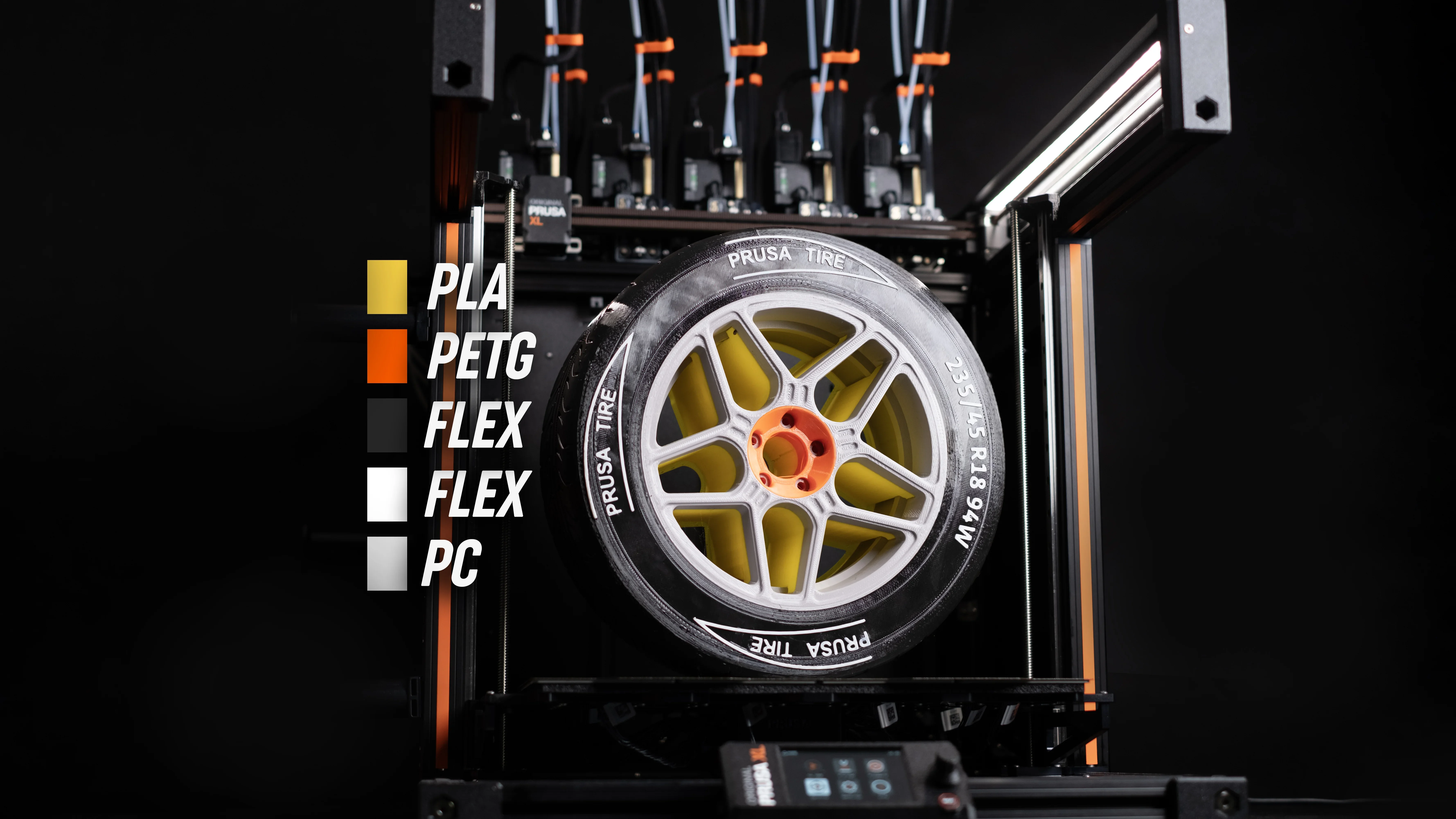 Prusa XL 3D printer with a detailed tire model using PLA, PETG, FLEX, and PC filaments, showcasing multi-material capabilities.