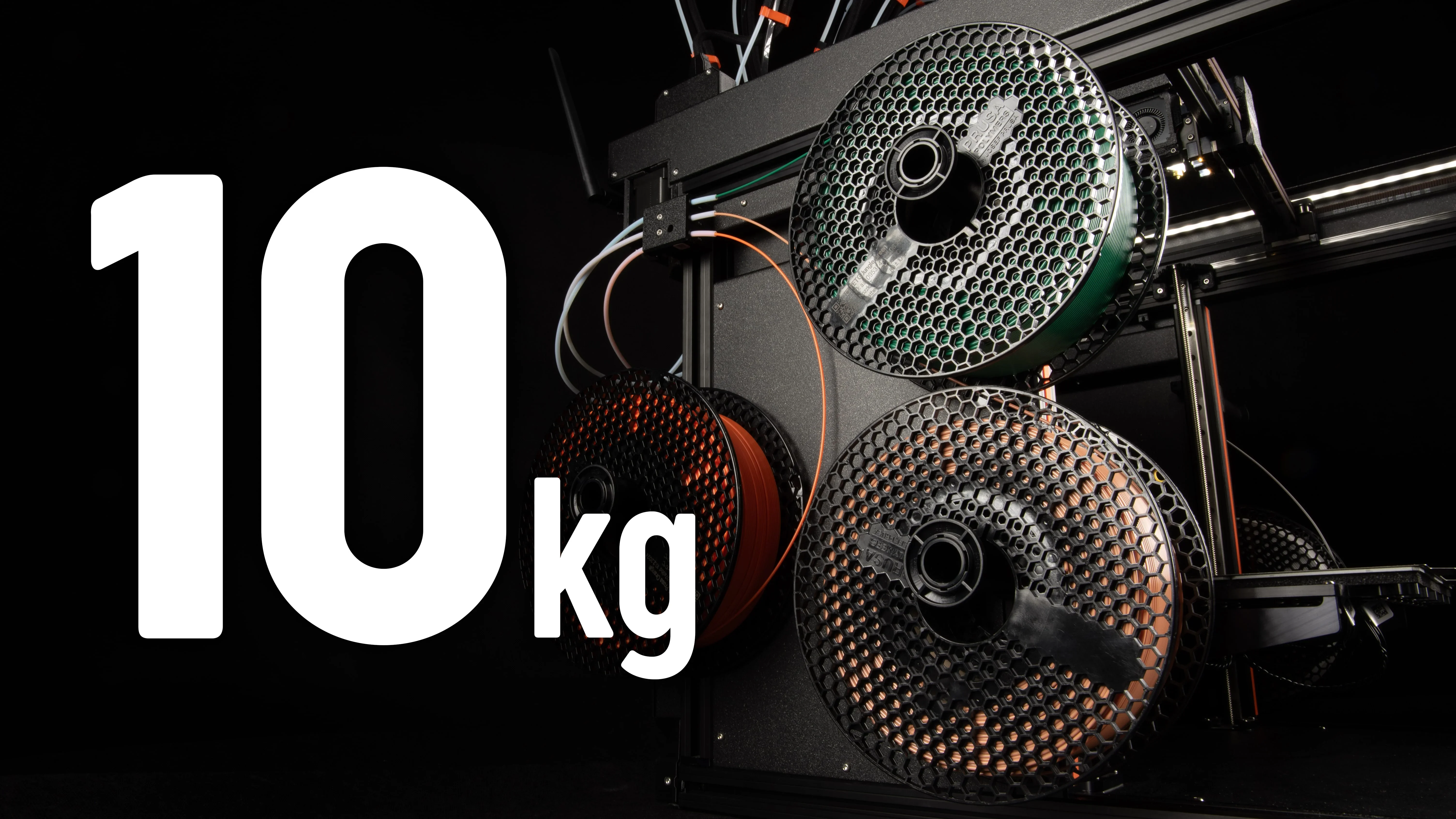 Prusa XL with hexagonal filament spools, stacked, on a black background with "10 kg" text in bold white.