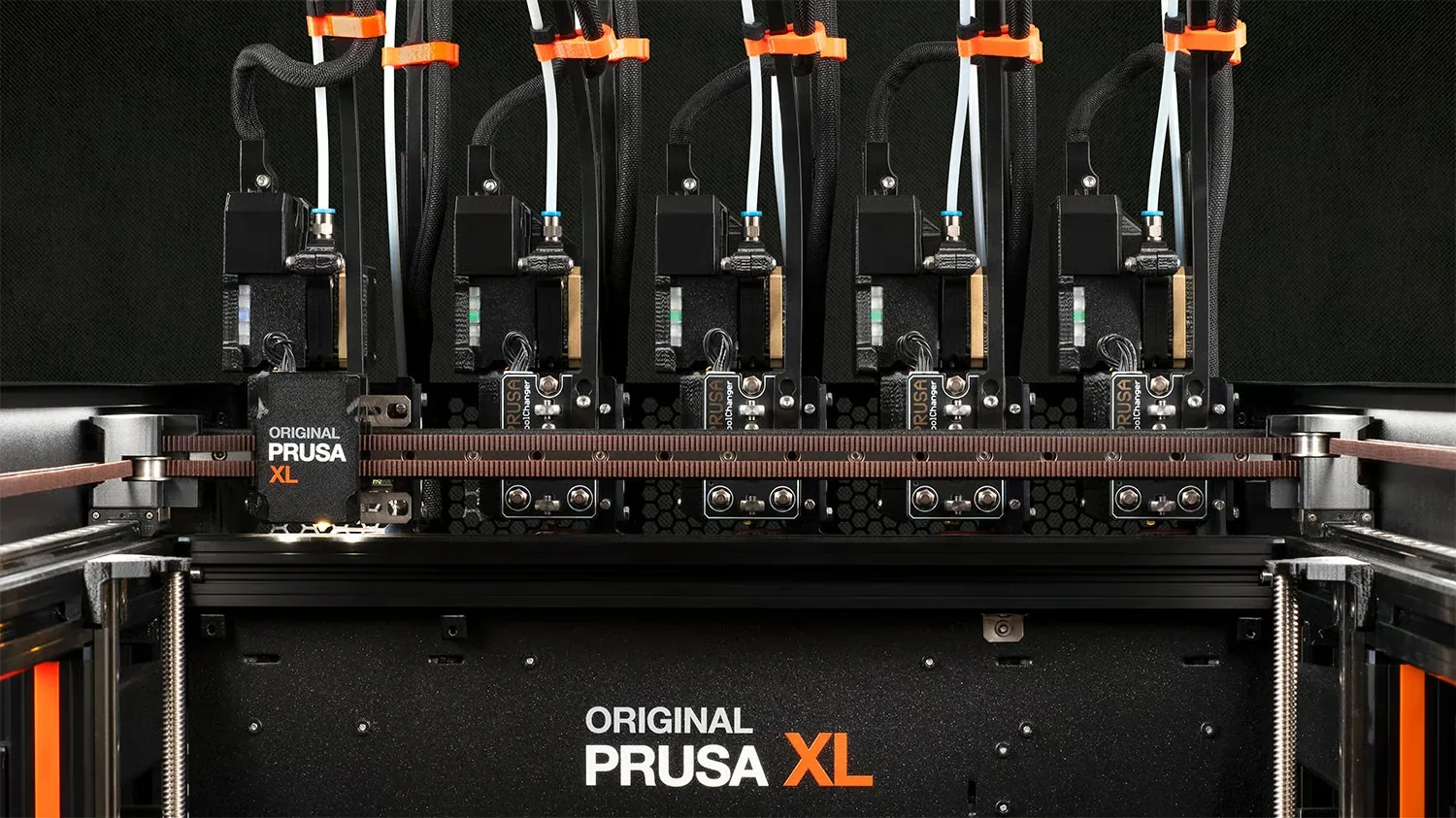 Prusa XL 3D printer with multiple nozzles and branding on a dark background, showcasing advanced printing capabilities.