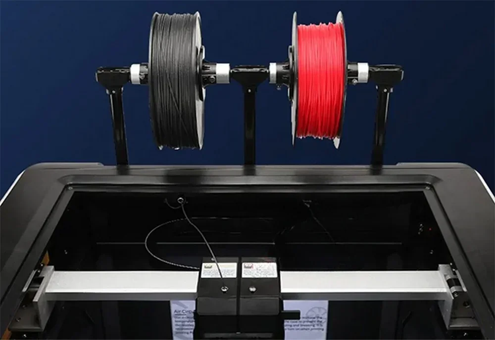 Qidi I-Fast 3D printer top view showing two filament spools, black and red, on holders above the printing area, set against a blue background.