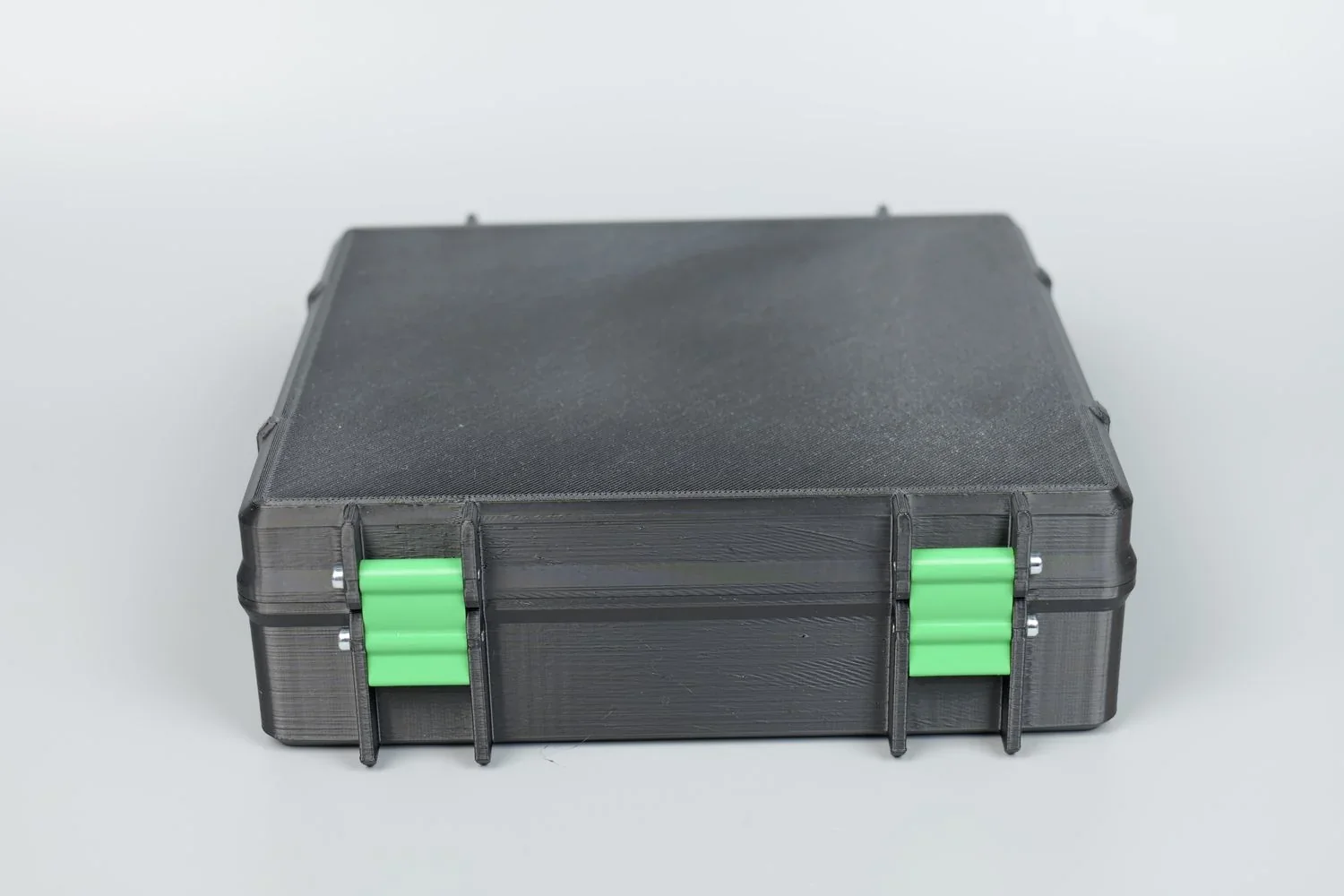 Black and green 3D-printed box by Qidi X Max, featuring textured finish and visible layered construction, with industrial design elements.