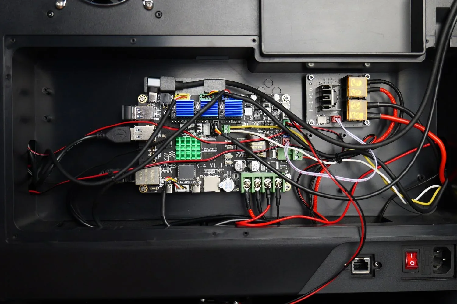 Qidi X Max 3D printer interior showing circuit board with wiring, electronic components, cooling fans, and power controls, highlighted for clarity.