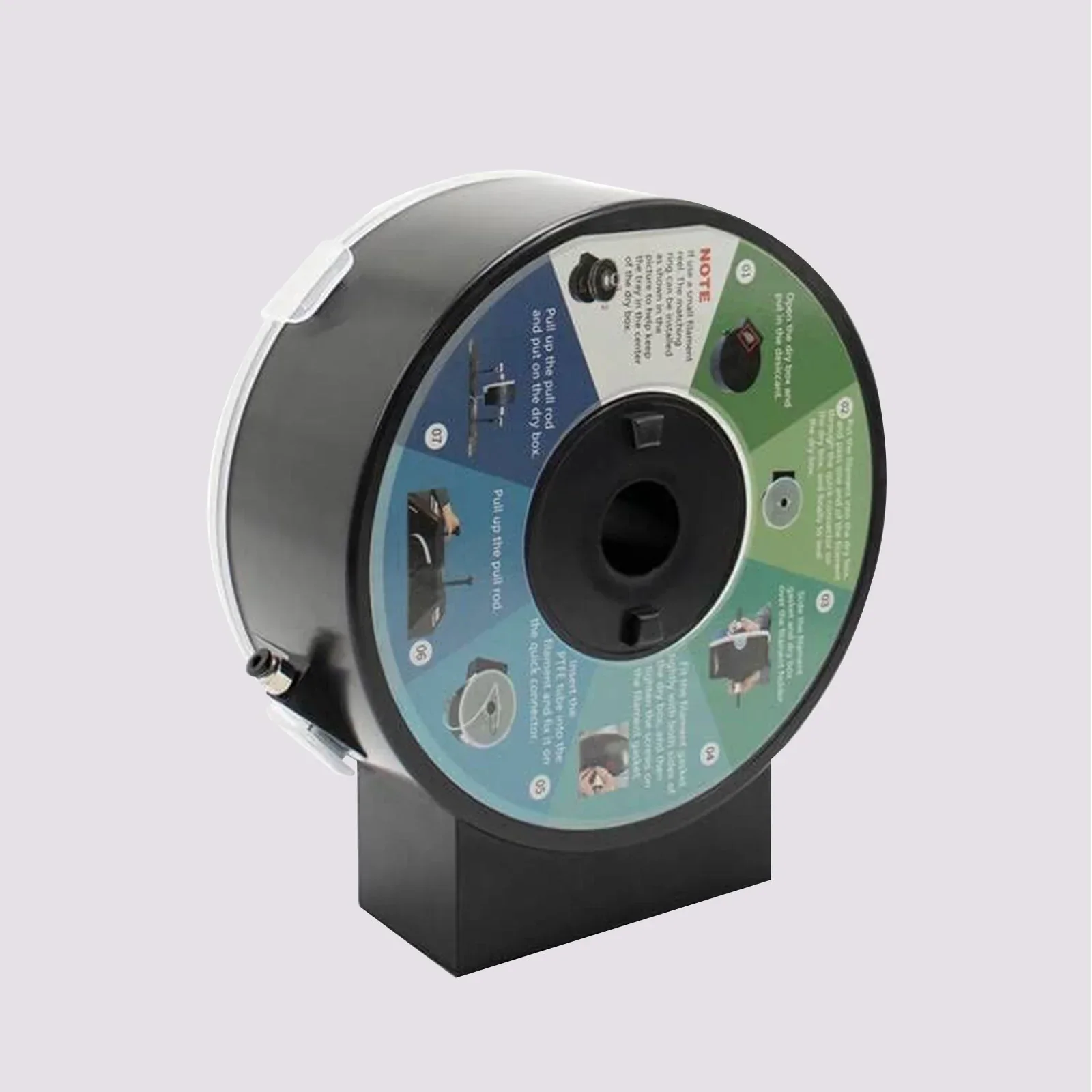 Black spool on stand with a multicolored instructional label, likely related to the Qidi X Max 3D printer setup or filament usage.