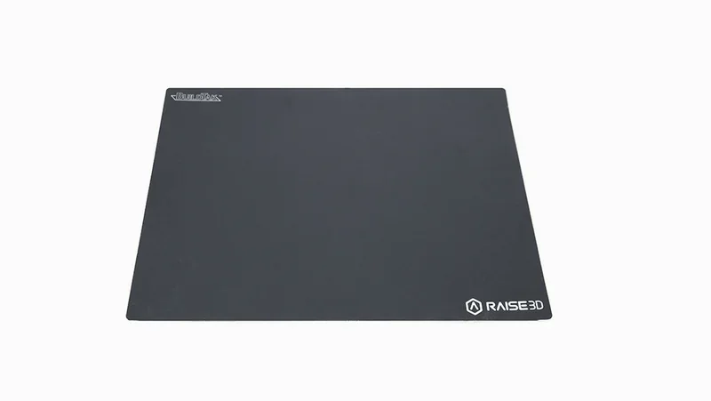 Raise3D E2 black magnetic build plate, with logo, for 3D printing samples and parts, isolated on a white background.