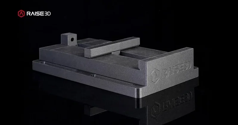 Raise3D E2CF-produced 3D printed part on a black background, featuring Raise3D logo, exhibiting a sleek, industrial design with precise detailing.