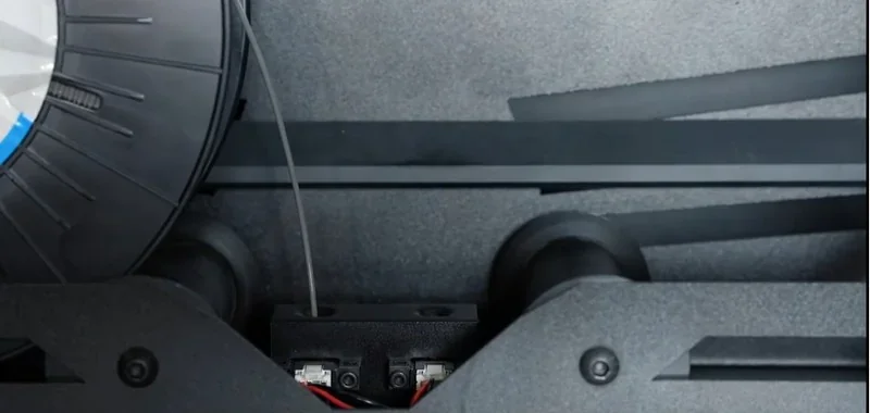 Raise3D MetalFuse printer showing filament spool and internal components, designed for precise, high-quality 3D printing of metal parts and samples.