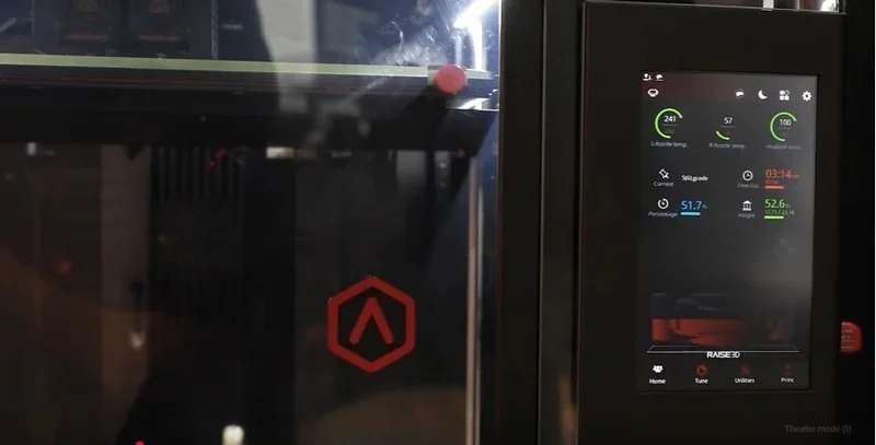 Raise3D MetalFuse 3D printer with control screen, showcasing its interface and a printed sample inside. Displaying branding and operational details.