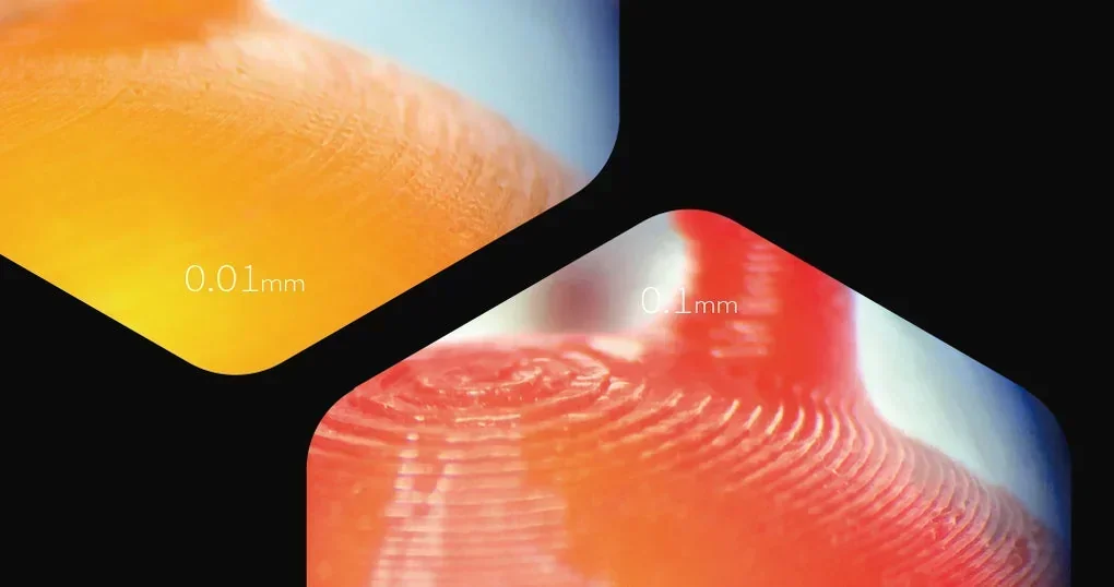 Close-up of 3D prints demonstrating layer resolution of 0.01mm and 0.1mm by the Raise3D Pro2 Plus, showcasing color and detail.