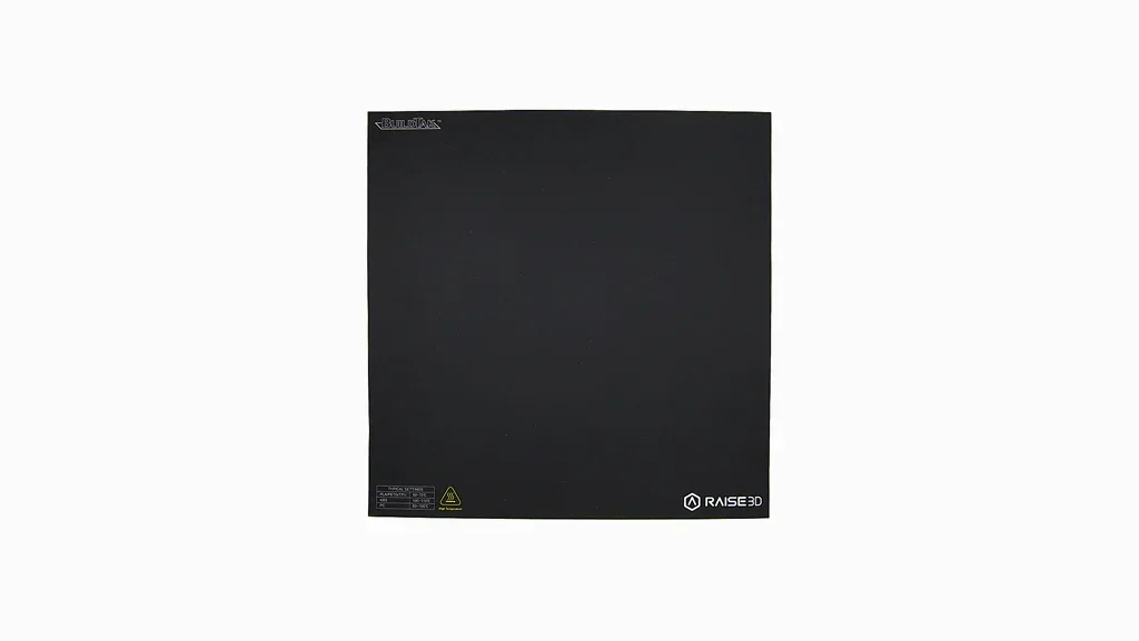 Black BuildTak FlexPlate System sheet for Raise3D Pro2 Plus 3D printer, featuring branding and caution label, designed for optimal print adhesion.