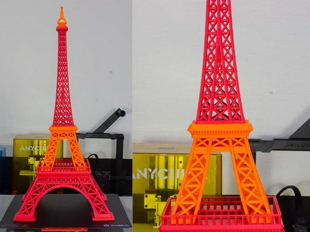 Colorful Eiffel Tower model 3D printed by Raise3D Pro3, showcasing intricate lattice design, positioned on a workspace with visible branding.