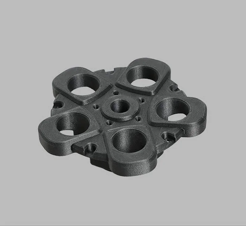 3D-printed black component with multiple holes, created by Raise3D Pro3 HS, displayed on a gray background.