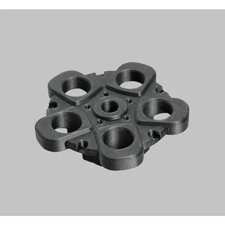 A black mechanical part with an array of round openings and a central hole, showcasing the fine detail possible with the Raise3D Pro3 HS 3D printer. The part appears robust, with smooth finishes and precise cutouts, demonstrating the printer's ability to handle complex geometric shapes.
