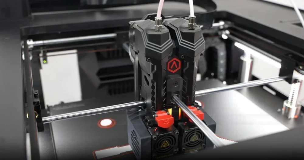 Raise3D Pro3 Plus 3D printer with dual extruders inside its chamber, featuring filament and mechanical components for precision printing.