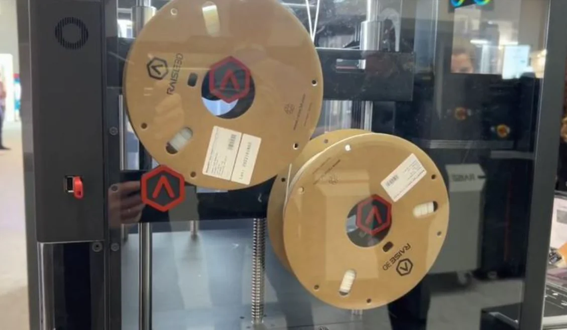 Raise3D Pro3 Plus interior with two filament spools mounted, showcasing branding and structure.