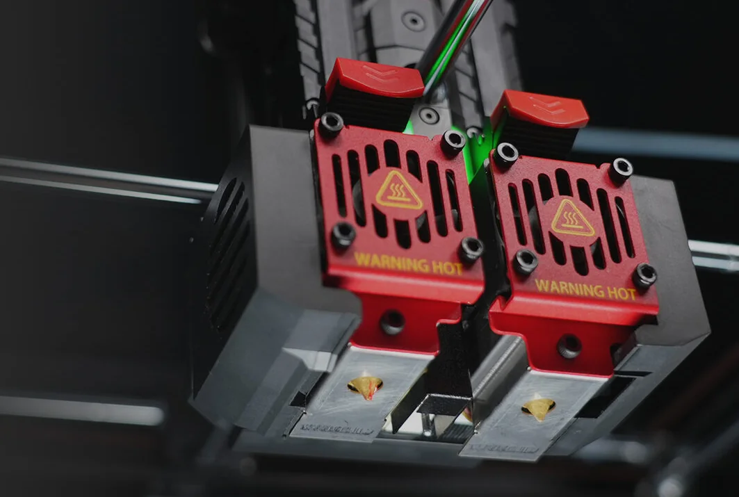 Raise3D Pro3 Plus HS dual extruders with red heat warning panels, detailed close-up, highlighting technical features and design elements.