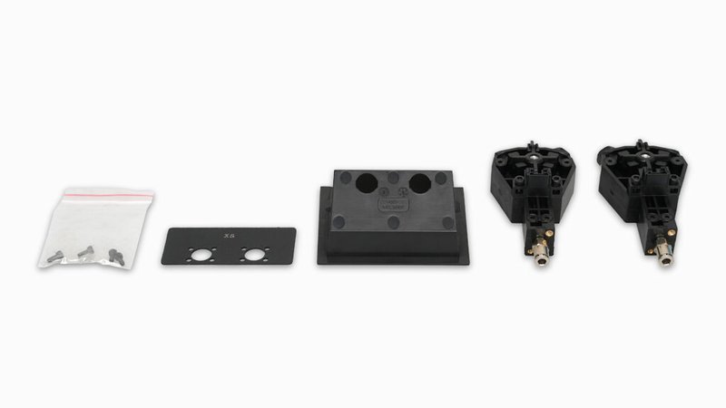 A set of components associated with the Raise3D Pro3 Plus HS 3D printer, laid out on a white background. Included are a small sealed bag of screws, a rectangular metal plate with two holes labeled 'X2', a black block with rounded edges, and two identical extruder components featuring brass nozzles. These parts are likely used for maintenance or customization of the 3D printer.