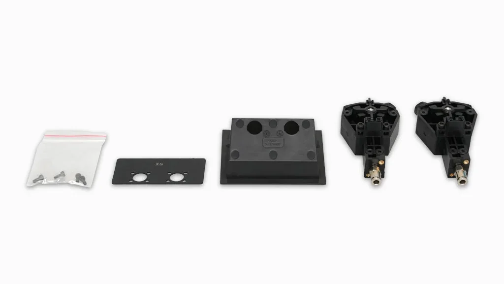 Raise3D Pro3 Plus HS parts, including screws, a black metal plate, a block, and two identical components, displayed against a white background.