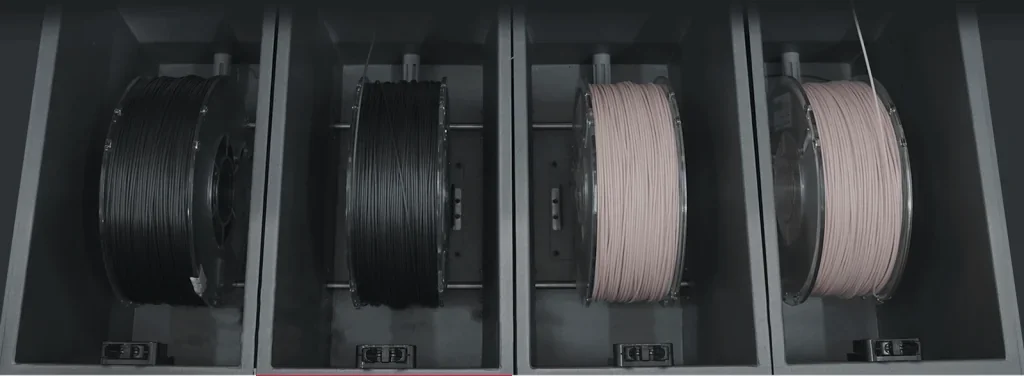 Raise3D RMF500 filament compartments with two black spools and two beige spools, showcasing materials used for 3D printing.